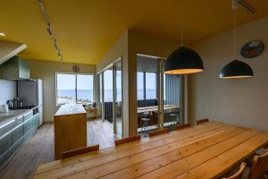 a kitchen and dining room with a large wooden table at 子どもがおもいっきり楽しめる一軒家　taiza child in Kyotango