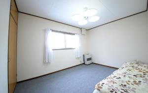 A bed or beds in a room at のんびれっじ　ハイランド館