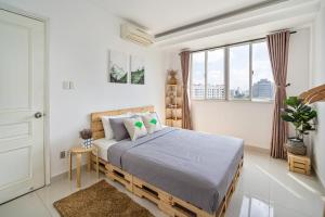 um quarto com uma cama num quarto com janelas em Alex House Saigon - Serviced Apartment em Ho Chi Minh