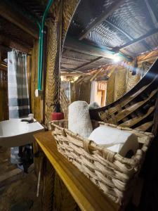 ein Badezimmer mit einer Bank mit einem Waschbecken und einem Korb in der Unterkunft Los Achiotes Hostal in Palomino