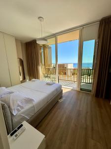 a bedroom with a large bed and a balcony at Villa Splendid Palase in Himare