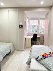 ein Schlafzimmer mit zwei Betten und einem Schreibtisch und einem Fenster in der Unterkunft Wonder House Estoril in Estoril + 12 Fotos