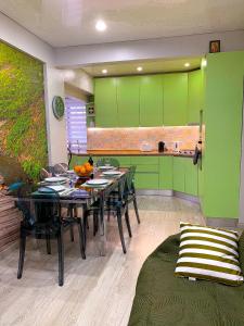 ein Esszimmer mit einem Tisch und grünen Schränken in der Unterkunft Wonder House Estoril in Estoril