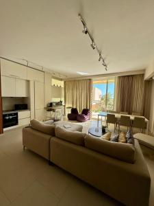 a living room with a large couch and a kitchen at Villa Splendid Palase in Himare