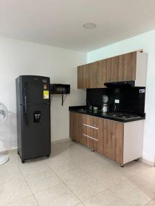 a kitchen with a black refrigerator and a counter at Casa quintas pitalito in Pitalito