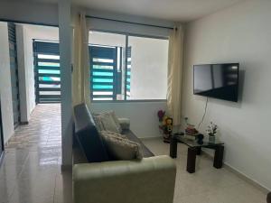 a living room with a couch and a tv at Casa quintas pitalito in Pitalito