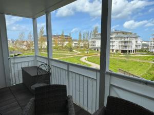 eine abgeschirmte Veranda mit 2 Stühlen und einem Tisch in der Unterkunft Appartement Cabourg, 2 pièces, 4 personnes - FR-1-487-365 in Cabourg