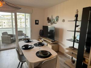 ein Wohnzimmer mit einem Tisch und einem TV in der Unterkunft Appartement Cabourg, 2 pièces, 4 personnes - FR-1-487-365 in Cabourg