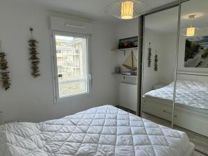 ein weißes Schlafzimmer mit einem Bett und einem Fenster in der Unterkunft Appartement Cabourg, 2 pièces, 4 personnes - FR-1-487-365 in Cabourg