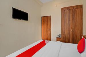 a bedroom with a bed with a television and a door at Flagship Silver Valley in Udaipur