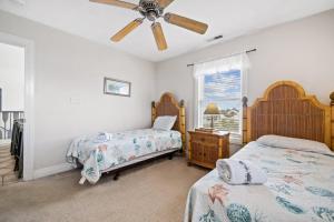 1 dormitorio con 2 camas y ventilador de techo en Anthem of the Sun en Virginia Beach