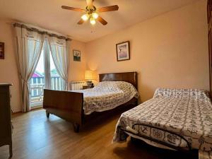 a bedroom with two beds and a ceiling fan at Appartement 2 pièces avec parking près de la plage - FR-1-246A-295 in Saint-Georges-dʼOléron