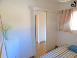 Zimmer mit einem Schlafzimmer mit einem Spiegel und einer Tür in der Unterkunft Appartement Bormes-les-Mimosas, 2 pièces, 4 personnes - FR-1-251-822 in Bormes-les-Mimosas