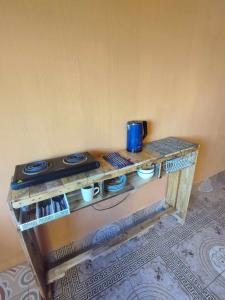 a wooden table with a stove and cups on it at La Casa Colorada in San Benito
