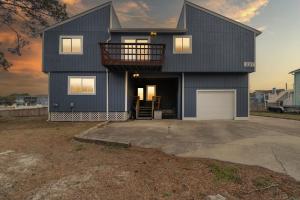 a black house with a balcony and a garage at Acadian Bay in Virginia Beach