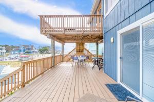 a deck with a balcony with a table and chairs at Acadian Bay in Virginia Beach