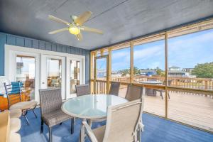 a dining room with a table and chairs on a deck at Acadian Bay in Virginia Beach
