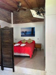 a bedroom with a red bed and a ceiling fan at Caleta del Sur in Las Grutas
