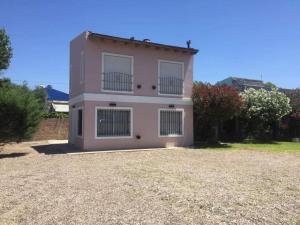 a pink house with two balconies on top of it at Caleta del Sur in Las Grutas