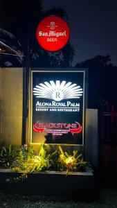 ein Schild für einen Alona Royal Palaiigh und ein Restaurant in der Unterkunft Alona Royal Palm Resort in Panglao