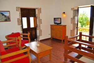 a living room with a table and chairs and a television at Casa Rural El Granero in Agüimes