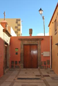 an orange building with a wooden door in a street at Casa Rural El Granero in Agüimes
