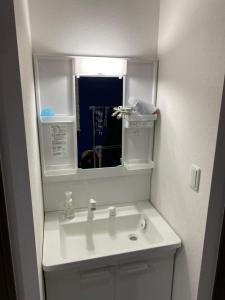 une salle de bains avec un lavabo blanc et un miroir dans l'établissement Wonderful stay TOKYO nakanoshinbashi, à Tokyo