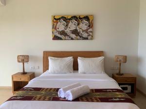 a bedroom with a bed with two towels on it at Bombora Balangan Resort in Ungasan