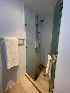 La salle de bains est pourvue d'une douche avec une porte en verre. dans l'établissement Getaway near Airport, à Guatemala