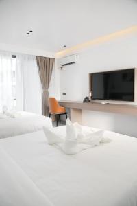 een hotelkamer met 2 bedden en een flatscreen-tv bij Willander Resort in Panglao