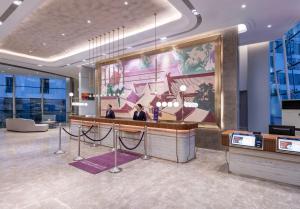 a lobby with a reception desk in a building at Mercure Beijing Downtown in Beijing