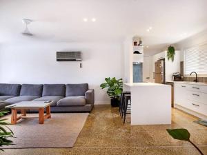 a living room with a couch and a kitchen at Benowa 1 Bedroom renovated townhouse in Gold Coast