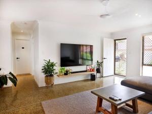 a living room with a couch and a flat screen tv at Benowa 1 Bedroom renovated townhouse in Gold Coast