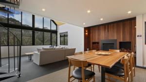 a dining room with a table and a couch at Woodrun in Dinner Plain
