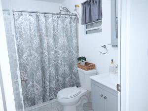 uma casa de banho com uma cortina de chuveiro e um WC em Casa Dona Guilla 1 