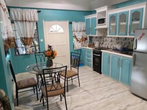 una cucina con armadi blu, tavolo e sedie di Argalo Suites 2 a Laborie