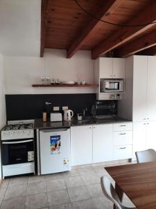 cocina con electrodomésticos blancos y techo de madera en Departamento céntrico en San Martín de los Andes