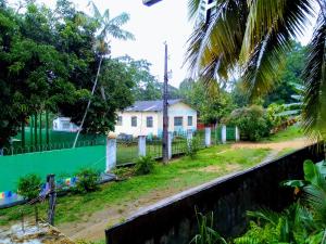 a house with a fence in front of a yard at Quarto compartilhado e camping in Manaus