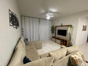 a living room with a couch and a tv at Apartamento até 8 pessoas Araxá Ótima localização in Araxá