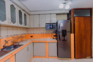 萬卡約的住宿－Casa - Huancayo - Zoológico Cerrito de la Libertad，带冰箱的厨房和电视。