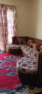 uma sala de estar com um sofá e um tapete vermelho em For Family شاليه em Suez