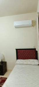 a bedroom with a bed with a red head board at For Family شاليه in Suez