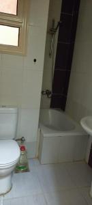 a bathroom with a toilet and a tub and a sink at For Family شاليه in Suez