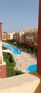 uitzicht op een zwembad in een resort bij For Family شاليه in Suez