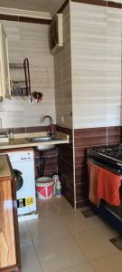 a kitchen with a sink and a washing machine at For Family شاليه in Suez