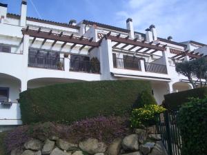 a white building with a hedge in front of it at Apartamento S'Agaró Fagoi in S'Agaro