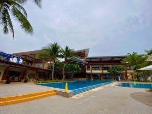 a hotel with a swimming pool in front of a building at Pico De Loro room Jacana A Bldg. in Nasugbu