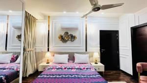 een slaapkamer met 2 bedden en een plafondventilator bij LMY Elysium Designer Luxury Apartments Facing Centaurs Mall Islamabad in Islamabad