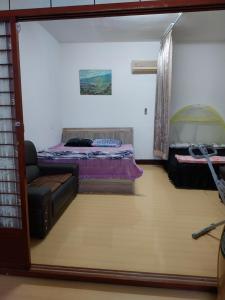 ein Wohnzimmer mit einem Bett und einem Sofa in der Unterkunft 三角窗民宿 