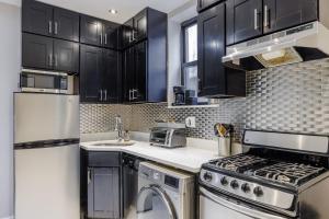 kuchnia z czarnymi szafkami i urządzeniami ze stali nierdzewnej w obiekcie Home is Where the Park is w Nowym Jorku